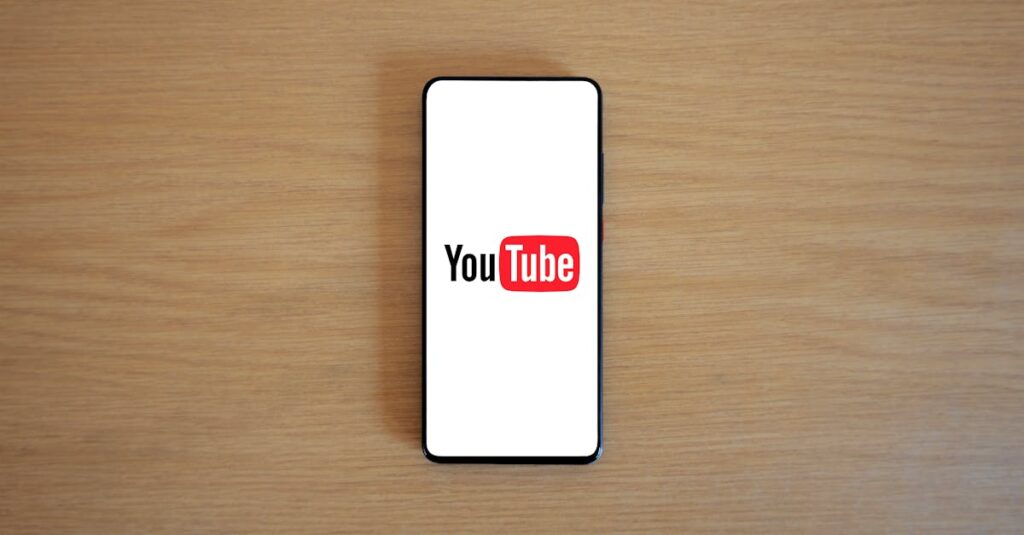 Top view of smartphone displaying YouTube logo on a wooden surface, showcasing modern technology.