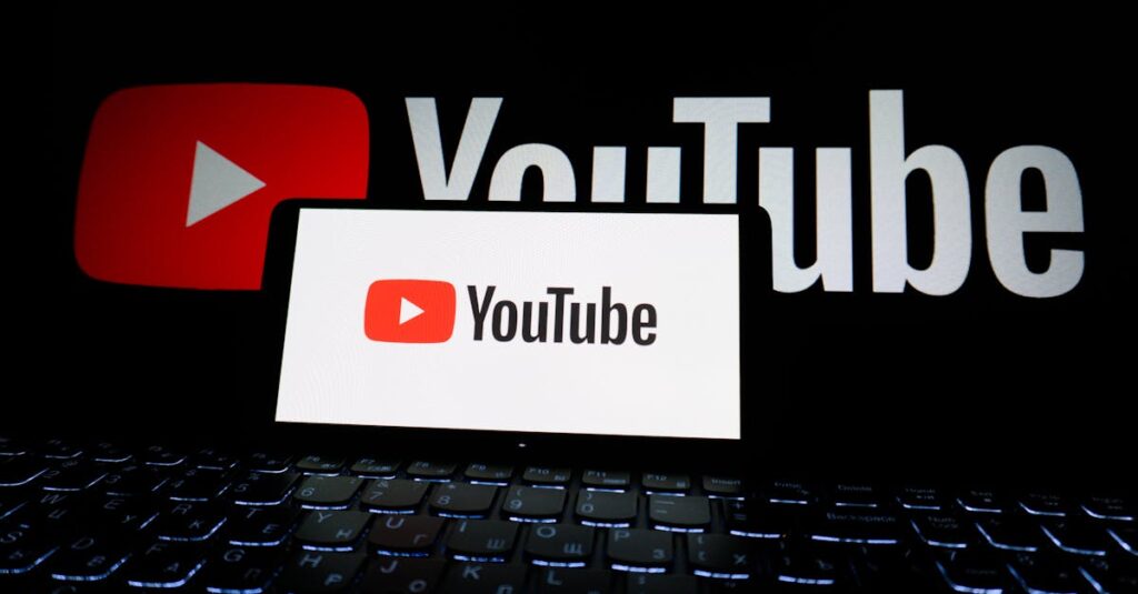 Close-up of YouTube logo displayed on a laptop screen in a dark environment.