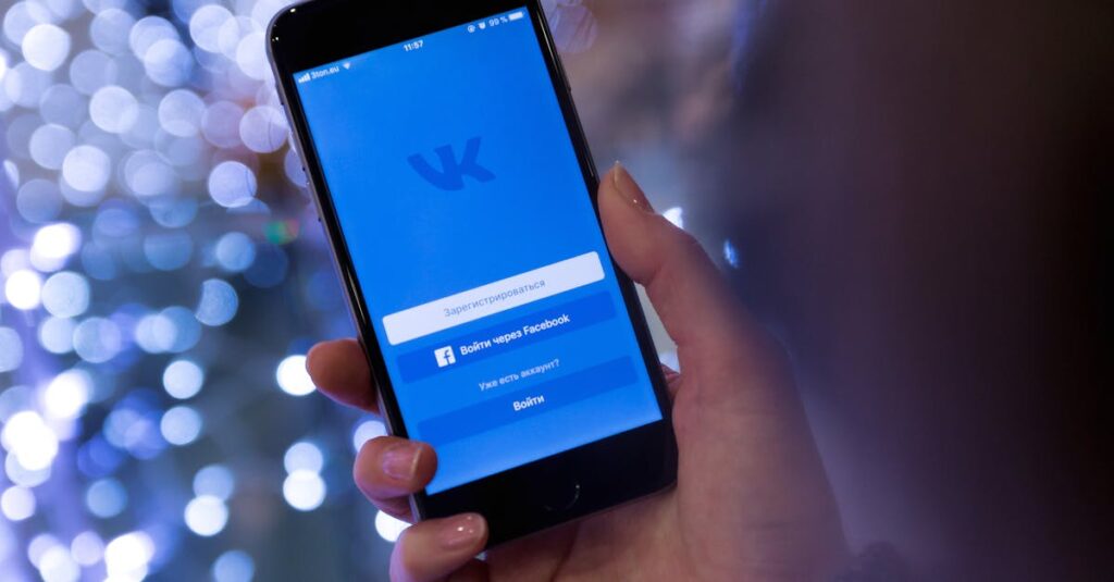 pexels-photo-834895-834895 A hand holding a smartphone displaying the VKontakte app login screen.